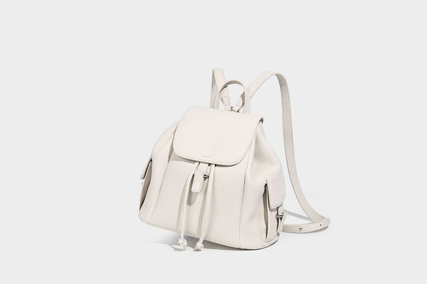 Compact pebbled leather-look flap drawstring backpack handbag with side pockets, top handle, and silver-tone hardware, detail