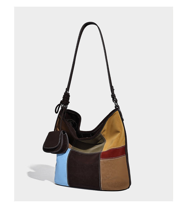 Lässig geschnittene Patchwork-Bucket-Bag mit dunkelbraunen, beigefarbenen, senfgelben, olivgrünen, roten und hellblauen Partien sowie kontrastfarbenen Nähten