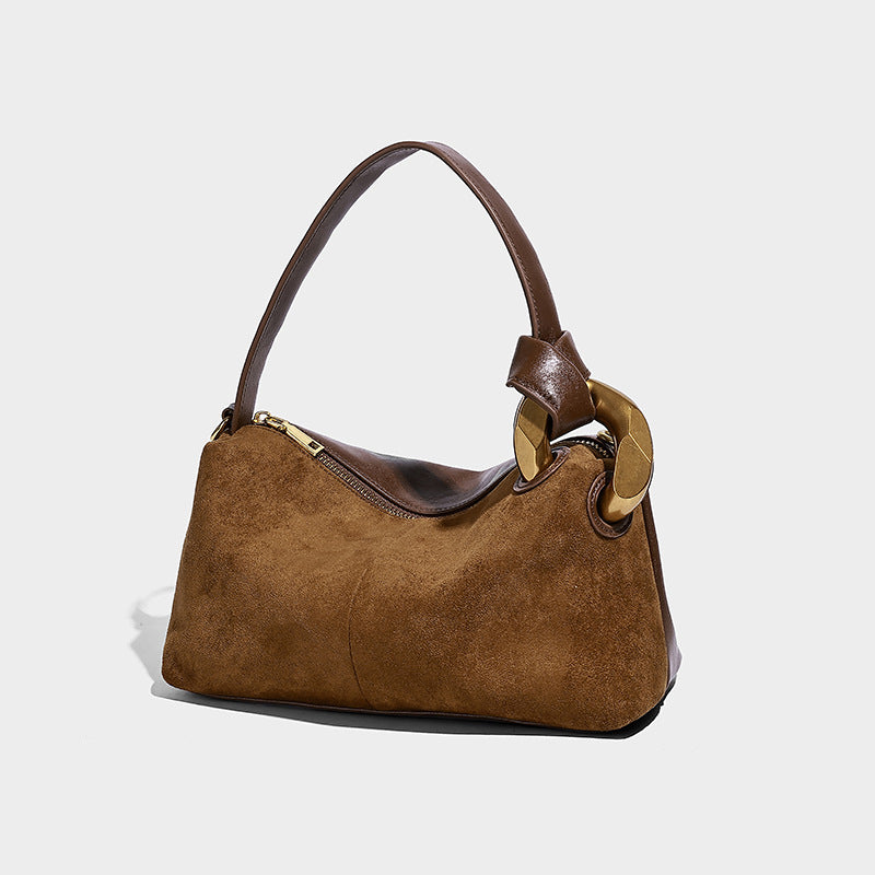 Kompakte Boston-Schultertasche in warmer, brauner Veloursleder-Optik mit glattem dunkelbraunem Besatz, übergroßem goldfarbenem Ringbeschlag und Reißverschluss oben