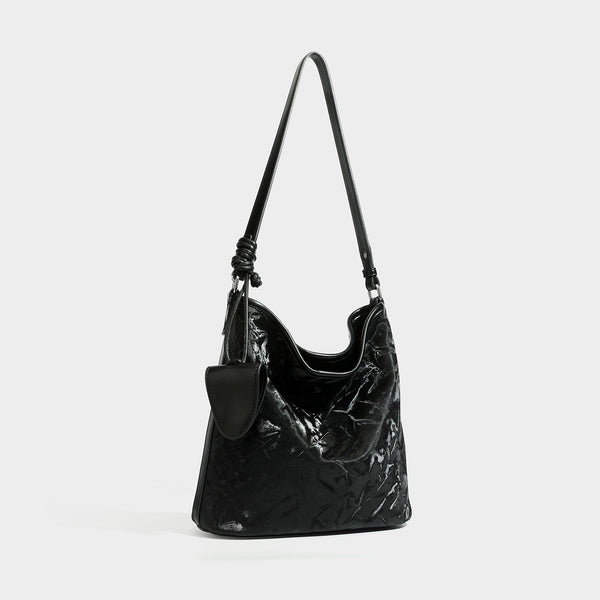 Große Hobo-Schultertasche mit Knitterglanz in tiefem Braun, schmalem verstellbarem Riemen, geknoteten Beschlägen und angesetztem seitlichem Überschlag