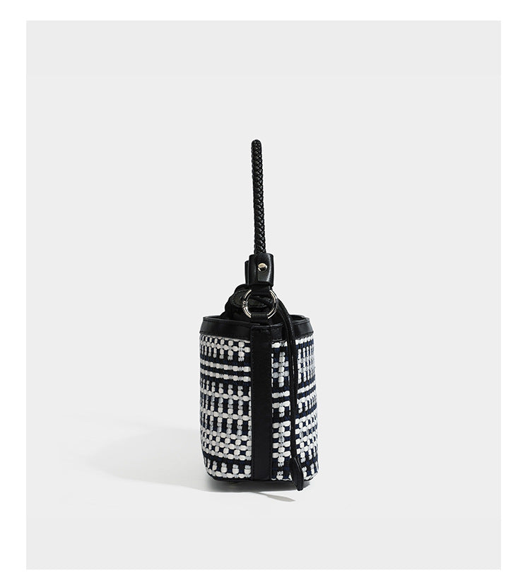 Small structured woven checker bucket bag with braided top handle, drawstring closure, and silver-tone hardware in black