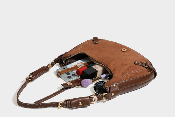 Halbmondförmige Schultertasche in camelbrauner Wildlederoptik mit weißen Kontrastnähten, goldfarbenen Beschlägen und