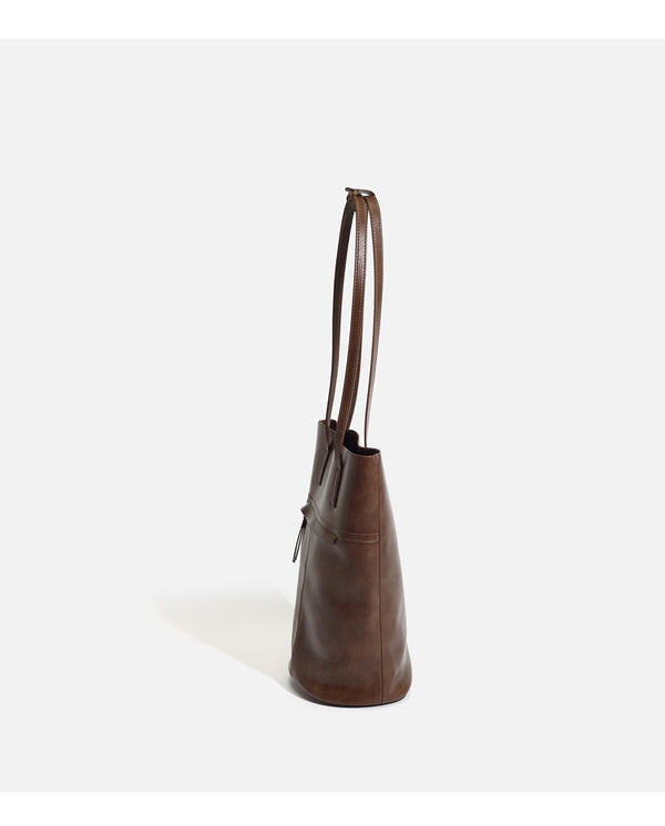 Large black smooth leather-look bucket tote bag with long shoulder straps and open top, detail view 9