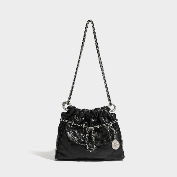 Glossy diamond-quilted drawstring bucket bag with silver chain shoulder strap and medallion charm, detail view 6