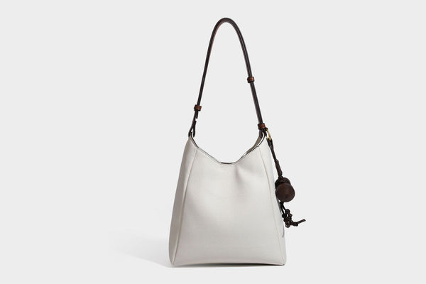 Hobo-Schultertasche in dunklem Espresso mit genarbter Oberfläche, warmen cognacfarbenen Details, verstellbarem schmalem Riemen, goldfarbenen Ringbeschlägen und geknotetem