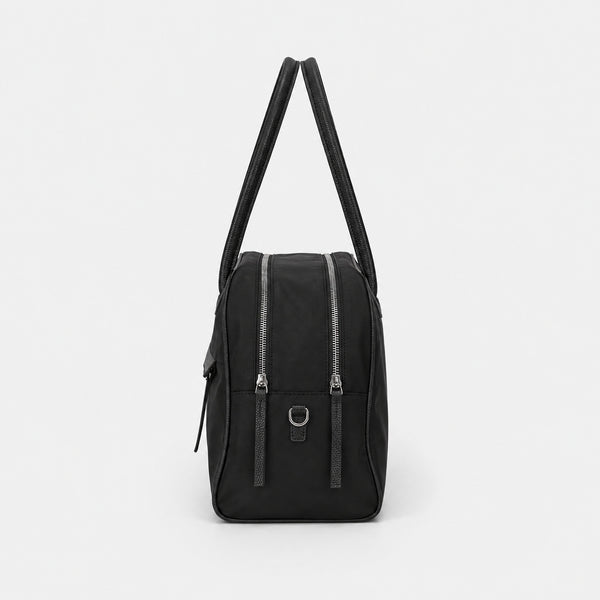 Structured dome top-handle bag in matte nylon with pebbled vegan leather-look trim, zip-top closure, front slip pocket, and