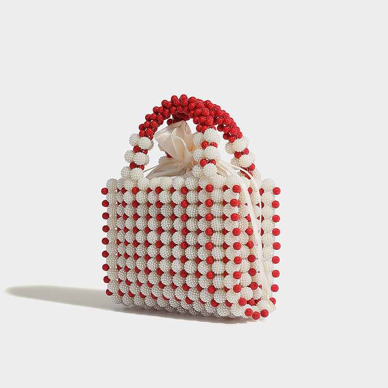 Small boxy pearl-bead mini top-handle bag with silver metallic bead accents, satin floral detail, and long beaded shoulder