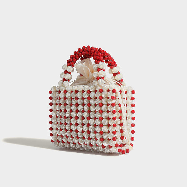 Small boxy pearl-bead mini top-handle bag with silver metallic bead accents, satin floral detail, and long beaded shoulder
