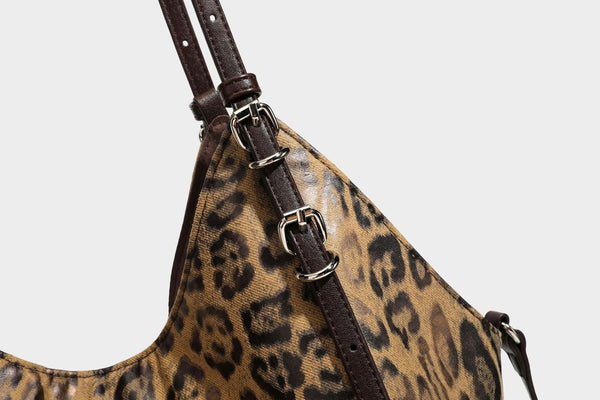 Slouchy leopard-print shoulder tote bag in tan and brown with long double straps, side tie straps, and dangling charm, detail