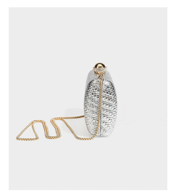 Small structured metallic woven-texture box clutch bag with jeweled kiss-lock dome clasp and slim gold chain strap, detail