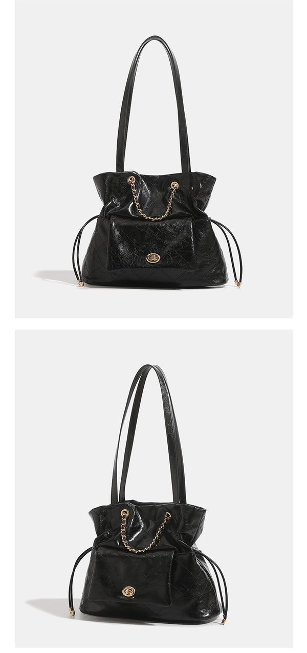 Black glossy diamond-quilted bucket tote bag with gold-tone chain accent, turn-lock front flap pocket, drawstring side ties