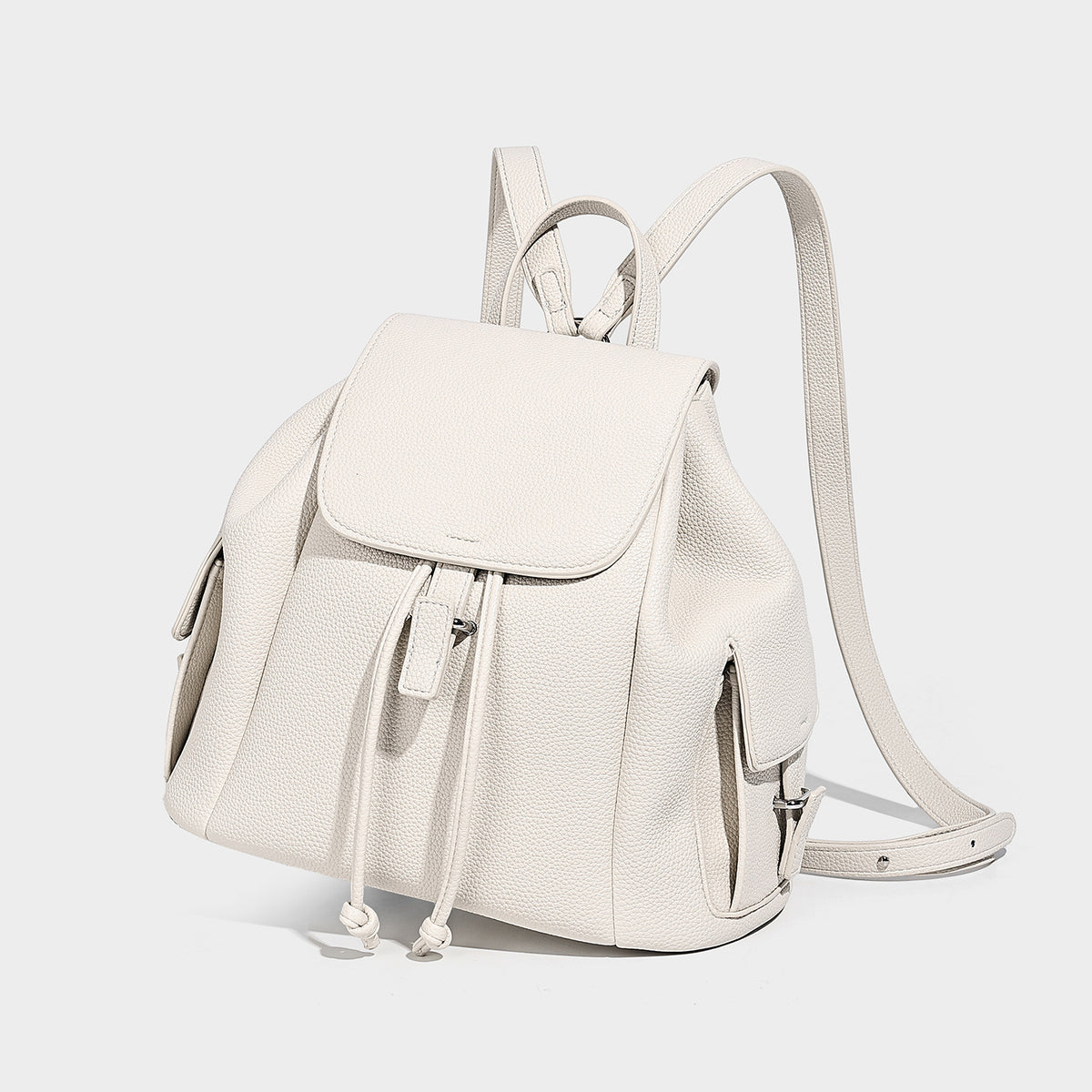 Compact pebbled leather-look flap drawstring backpack handbag with side pockets, top handle, and silver-tone hardware, detail