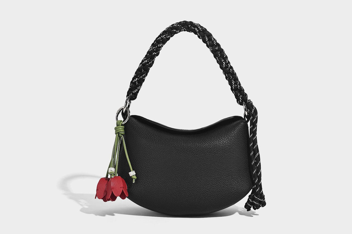 Small crescent half-moon bag in pebbled leather-look finish with braided top handle, silver-tone ring hardware, and, detail