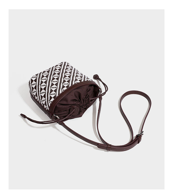 Kleine gewebte geometrische Bucket-Bag mit geflochtenem Henkel in Lederoptik und Kordelzugverschluss im zweifarbigen Muster aus Braun und Weiß