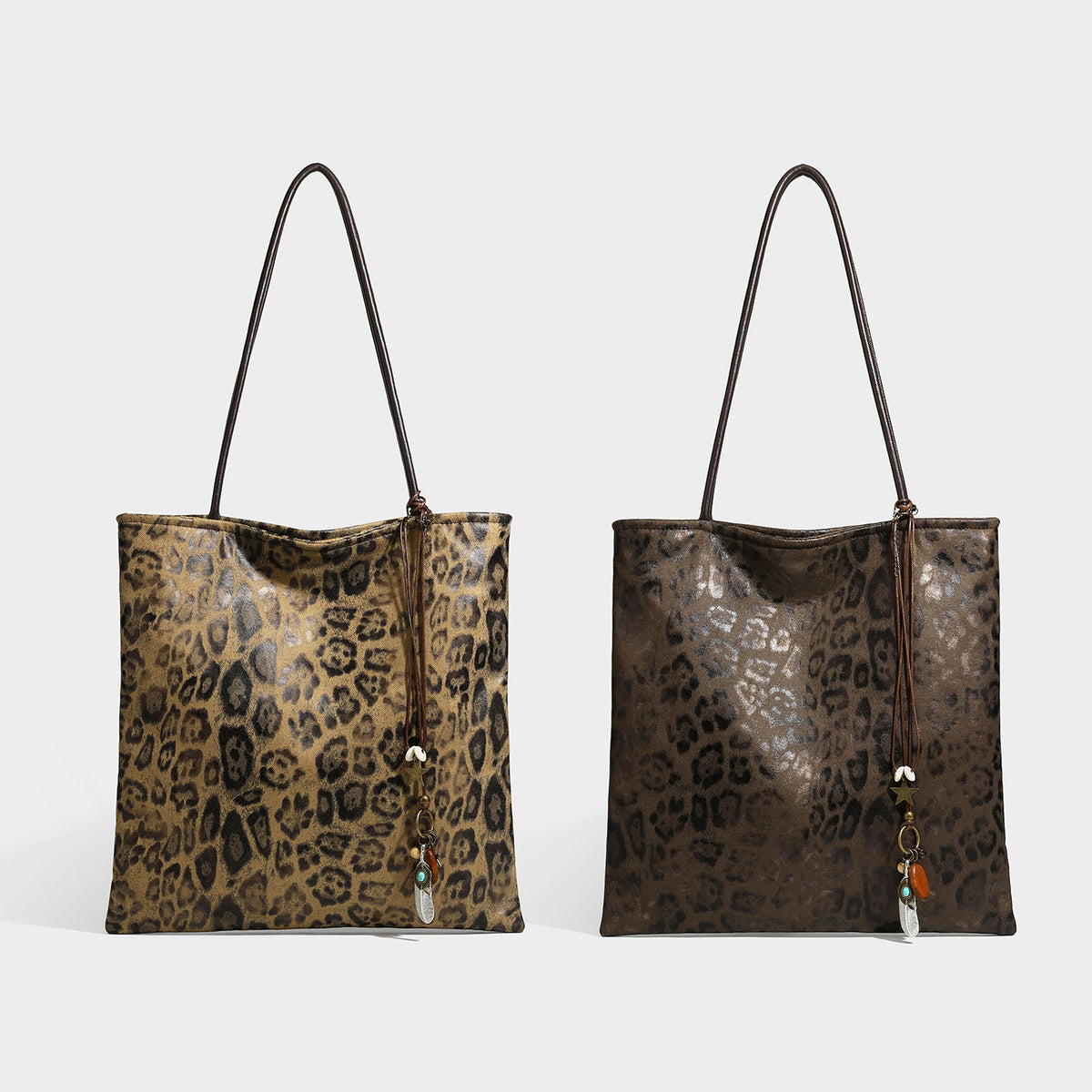 Large leopard print shoulder tote bag in tan and brown with slim dark straps and dangling beaded charm hardware, detail view