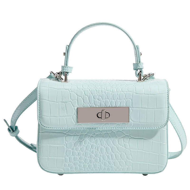 Small structured rectangular satchel with glossy crocodile-embossed finish, arched top handle, front flap, and silver-tone