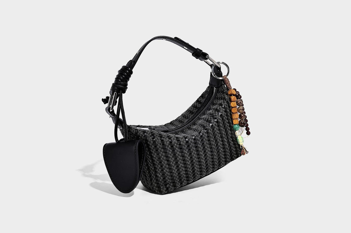 Woven crescent shoulder bag with leather-look knotted handle, zip top, attached mini pouch, and silver-tone hardware, detail