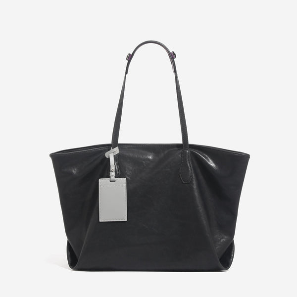 Large leather-look tote bag with trapezoid silhouette, double shoulder straps, and detachable hanging tag, detail view 6