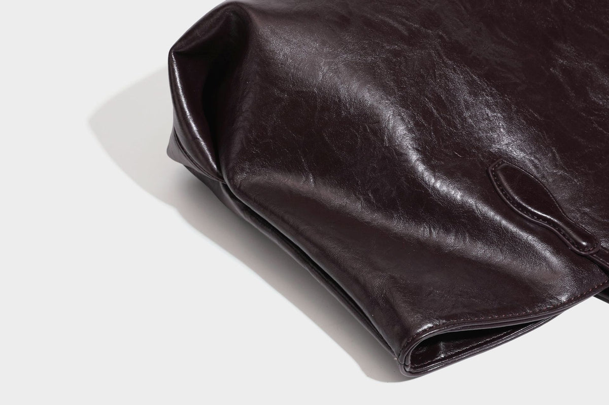 Übergroße, lässig fallende Tote-Bag aus glänzendem, geknittertem Lederimitat in dunklem Burgunderrot mit zwei langen Schulterriemen und kontrastierendem