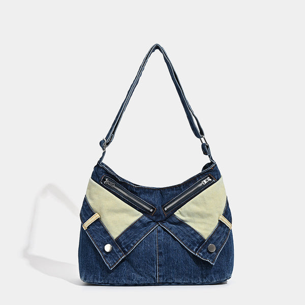 Schultertasche aus indigoblauem Denim mit hellen Kontrastpartien, sichtbarem Reißverschluss in Silberoptik, Druckknopfdetails und langem verstellbarem