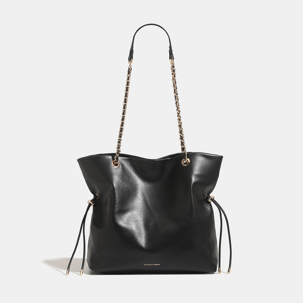 Soft-structured leather-look tote bag with gold-tone chain-and-strap shoulder handles and side drawstring cinches, front view