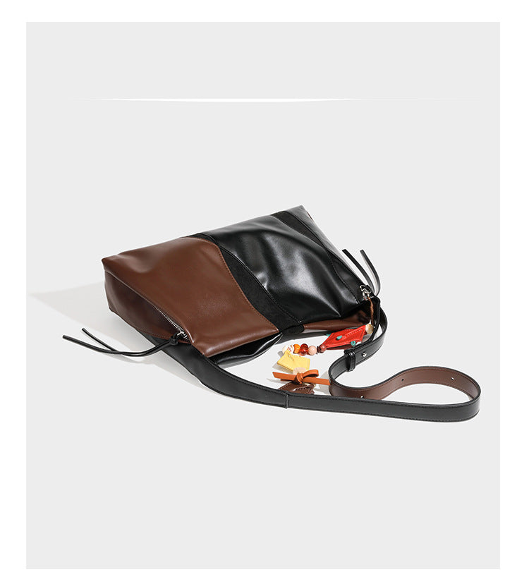 Two-tone black and brown leather-look slouchy shoulder bag with beaded tassel charm and silver-tone hardware, detail view 11
