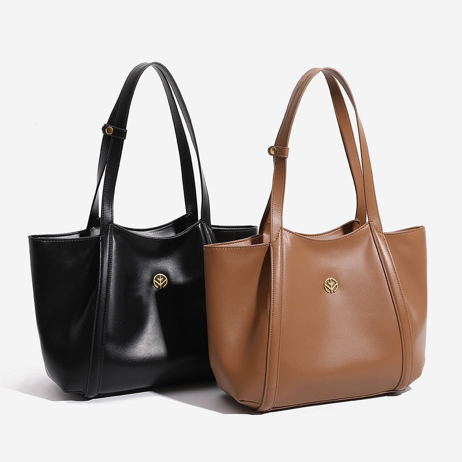 Structured open-top leather-look tote bag with long shoulder straps and gold-tone circular emblem hardware, front view