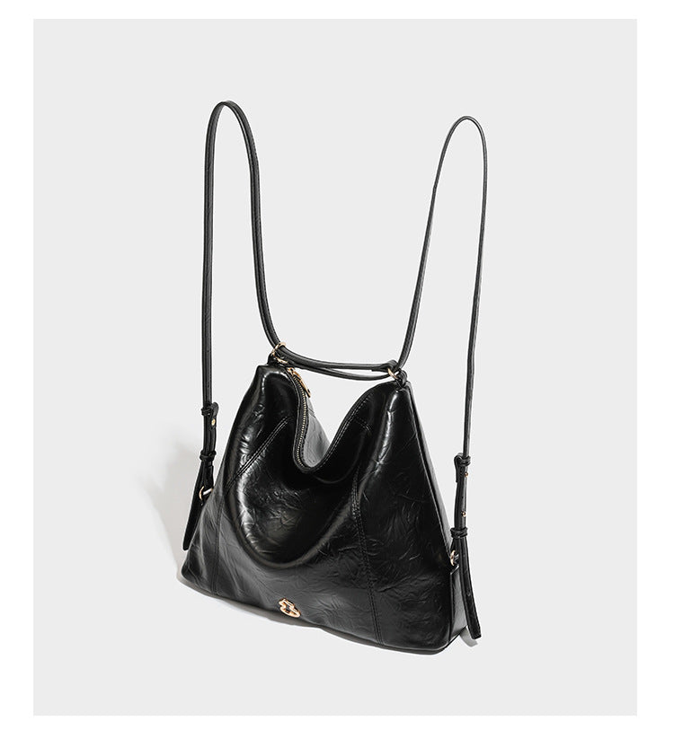 Große, lässig fallende Hobo-Schultertasche in glänzender, geknautschter Lederoptik mit goldfarbenen Beschlägen und langem, verstellbarem Riemen