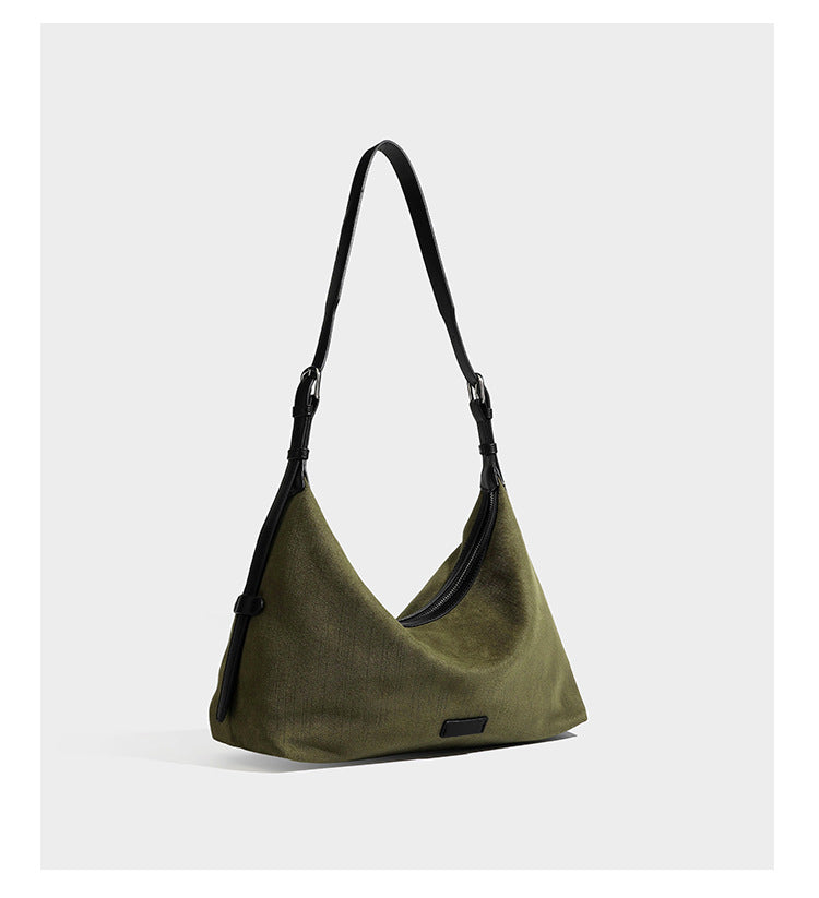 Slouchy olive green canvas hobo shoulder bag with black leather-look trim, zip-top closure, and adjustable strap, detail view