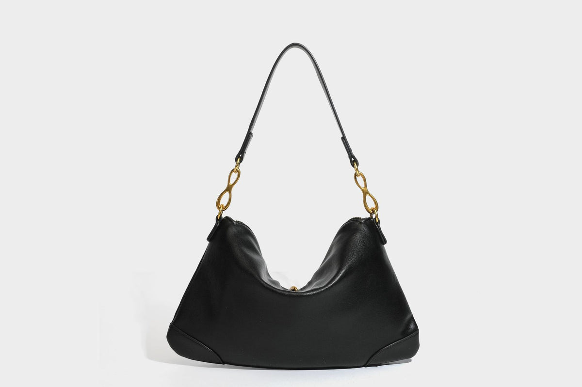 Slouchy denim shoulder bag with dark leather-look trim, gold-tone chain-link hardware, and top zipper closure, detail view 21