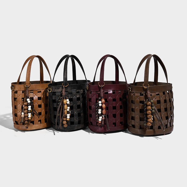 Small woven lattice bucket bag in brown leather-look finish with beaded tassel charm, dual top handles, and detachable