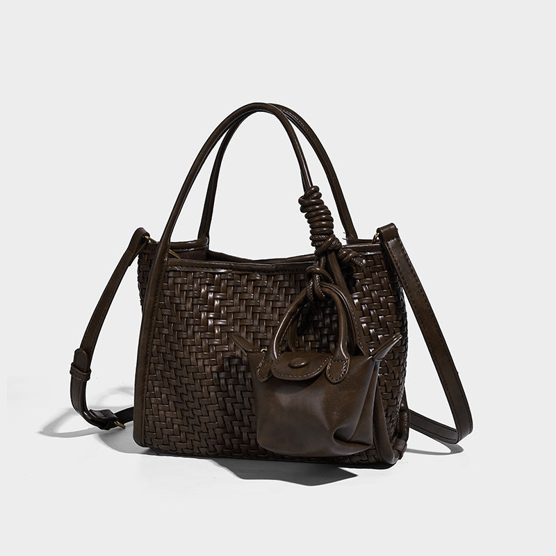 Offene Tote-Bag mit gewebter Struktur, glatten Henkeln mit Details in Lederoptik und befestigtem Mini-Beutel mit Kordelzug in Dunkelbraun, Vorderansicht