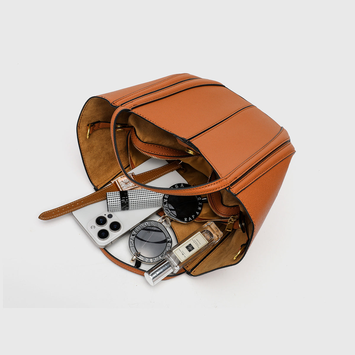Structured open-top tote bag in tan brown pebbled leather-look finish with vertical seam accents, black edge piping, curved