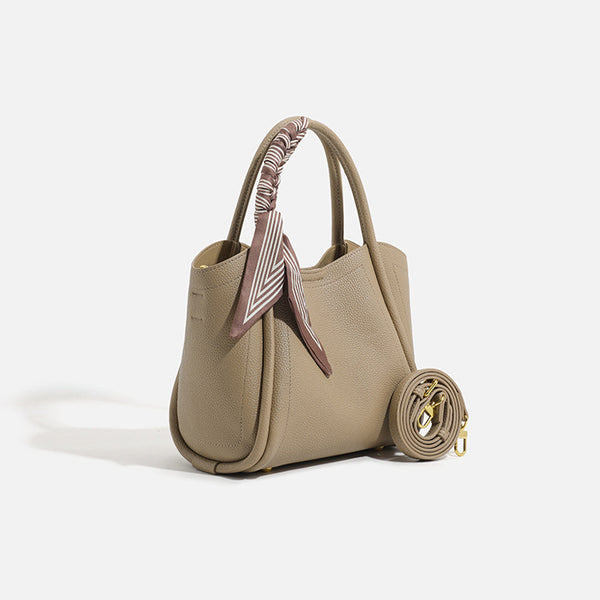 Pebbled leather-look bucket tote bag with scarf-wrapped top handle and gold-tone hardware, front view