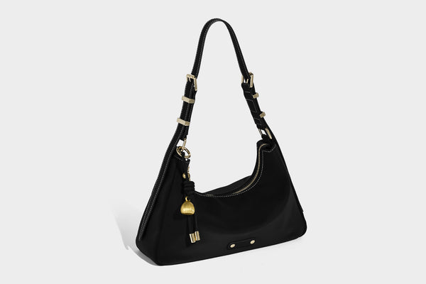 Crescent hobo shoulder bag in pebbled leather-look finish with top zipper, adjustable strap, gold-tone ring hardware, and
