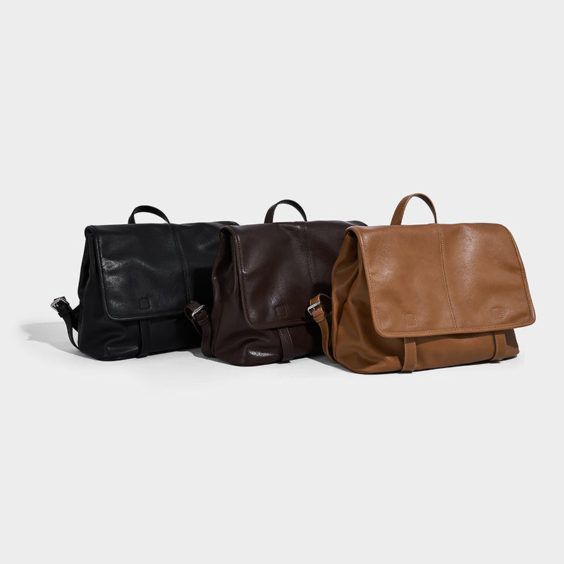 Structured tan leather-look flap backpack handbag with top handle, silver buckle hardware, and fold-over front closure