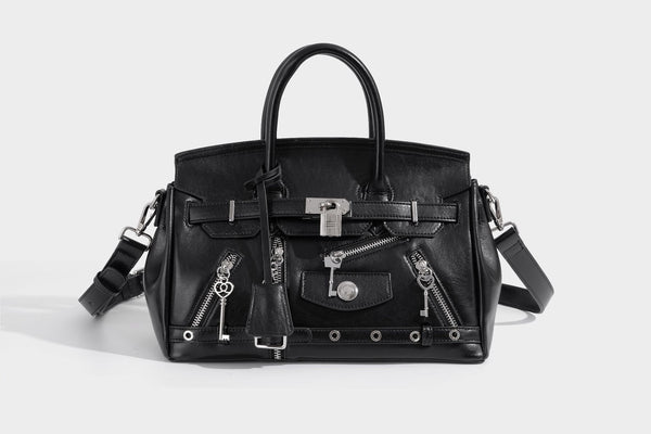 Structured black leather-look satchel bag with silver padlock hardware, front zip pockets, key charms, and top handles