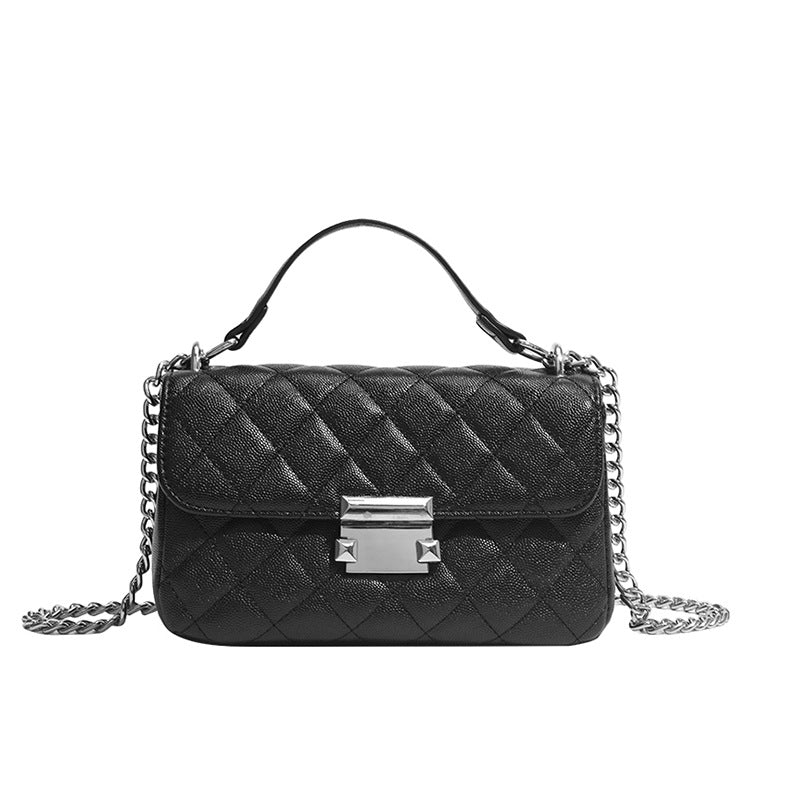 Kleine strukturierte Schultertasche mit Rautensteppung, doppeltem silberfarbenem Kettenriemen und rechteckigem silberfarbenem Verschluss, Detailansicht