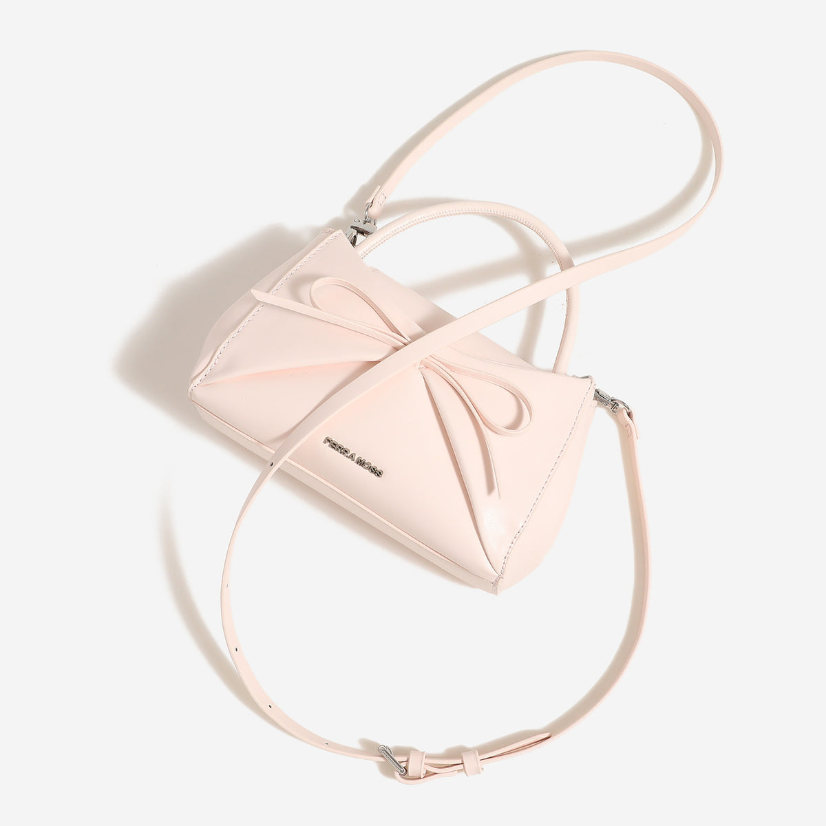Small structured trapezoid handbag with a three-dimensional front bow, short top handle, and detachable shoulder strap