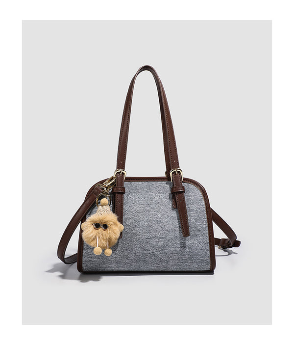 Small structured grey fabric shoulder bag with brown leather-look trim, gold-tone hardware, dual top handles, and detachable