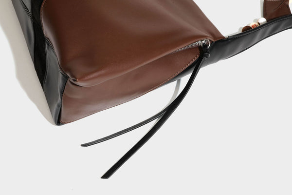 Two-tone black and brown leather-look slouchy shoulder bag with beaded tassel charm and silver-tone hardware, detail view 34