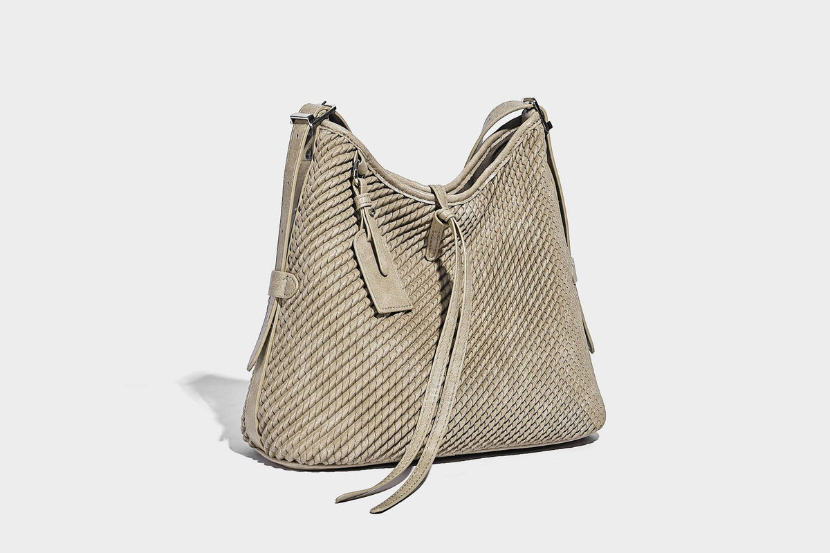 Große Schultertasche im Beuteltaschenstil mit Flechtstruktur, glatten Besätzen in Lederoptik, verstellbarem Riemen und Anhänger-Detail, Detailansicht
