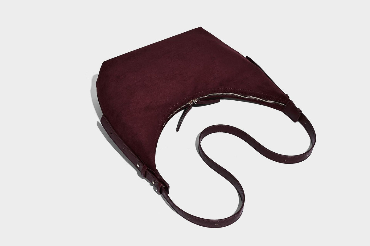 Slouchy crescent hobo shoulder bag in dark chocolate matte suede-look finish with adjustable strap and twin-pull top zip