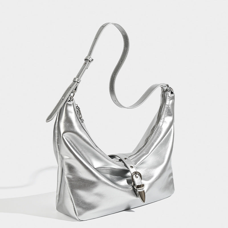 Slouchy crescent hobo bag with glossy leather-look finish, silver-tone buckle hardware, and flat shoulder strap, detail view