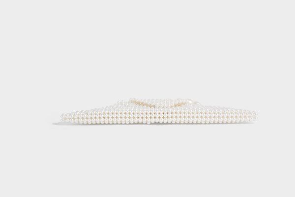 Small structured triangle clutch bag covered in glossy pearl beads with an arched pearl top handle and silver snap closure