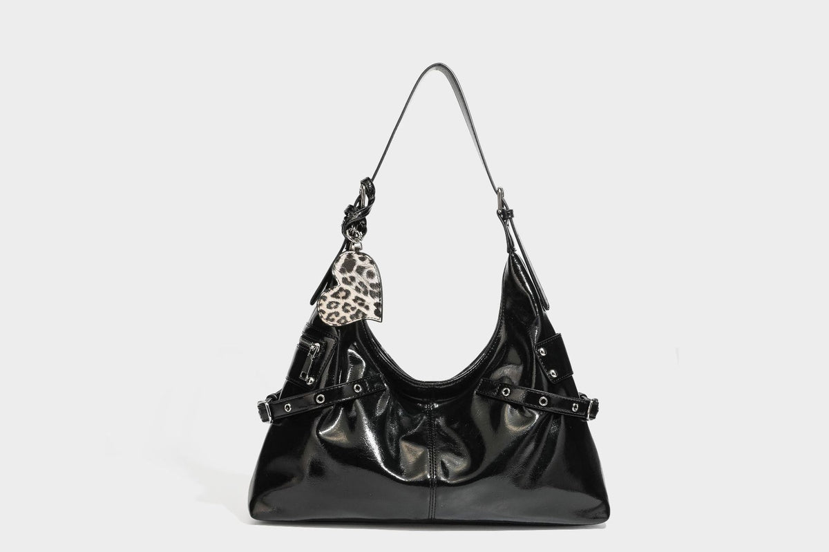 Glänzende dunkelbraune, lässig geschnittene Hobo-Schultertasche mit Riemendetail mit silberfarbenen Ösen, Reißverschlussfach auf der Vorderseite und Herz mit Leopardenmuster