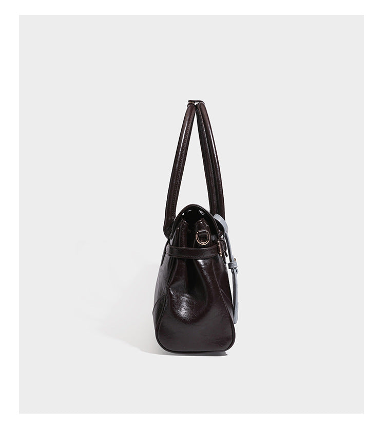 Structured glossy leather-look satchel bag with flap closure, gold-tone buckle accents, double top handles, detachable