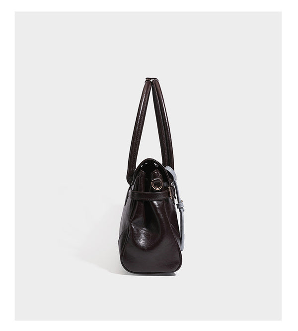 Structured glossy leather-look satchel bag with flap closure, gold-tone buckle accents, double top handles, detachable
