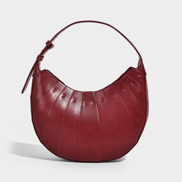 Crescent half-moon shoulder bag with vertical panel seaming, matte-satin leather-look finish, and adjustable gold-tone