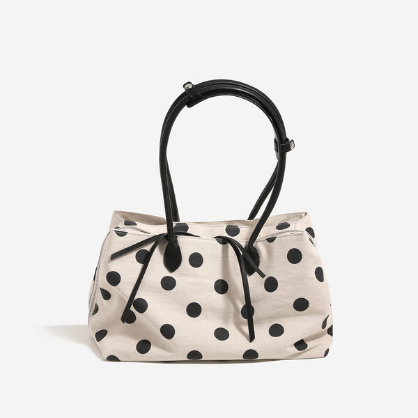 Cream canvas tote bag with black polka dots, rounded leather-look handles, and zip-top closure, detail view 6